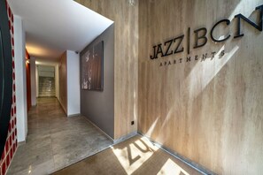 A hallway with a wooden wall and a sign that reads 'JAZZ BCN APARTMENTS'.