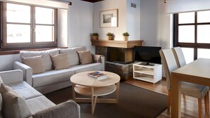 A modern living room with a sofa, a coffee table, a fireplace, and a TV. - Val de Ruda 18 by FeelFree Rentals (Baqueira)