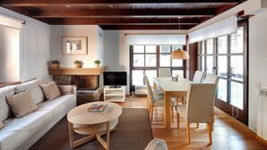 A modern living room with a sofa, coffee table, and dining area. - Val de Ruda 18 by FeelFree Rentals (Baqueira)
