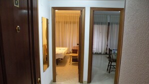 Ein Hotelzimmer mit Bett, Sessel, kleinem Tisch und Spiegel.