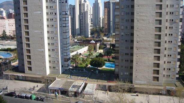 A high-rise residential building with multiple balconies, a rooftop pool, and a small park area. - FINLANDIA (1 BEDROOM) (Benidorm)