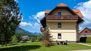 Une maison à deux étages dotée d’un balcon, d’une allée pavée et d’une pelouse bien entretenue.