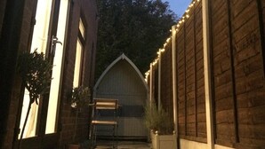 A narrow alleyway with a wooden shed in the center, flanked by brick buildings. - 'The Snug' nr York: stunning self-contained studio @ Old Station Master's House. (Riccall)
