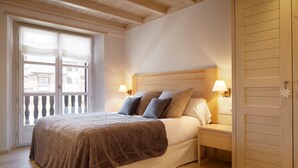 Una camera da letto con una testiera in legno, un letto grande con una coperta marrone, due lampade ai comodini e un armadio in legno.