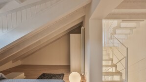 Un intérieur moderne avec un escalier en bois, un radiateur et un luminaire rond.
