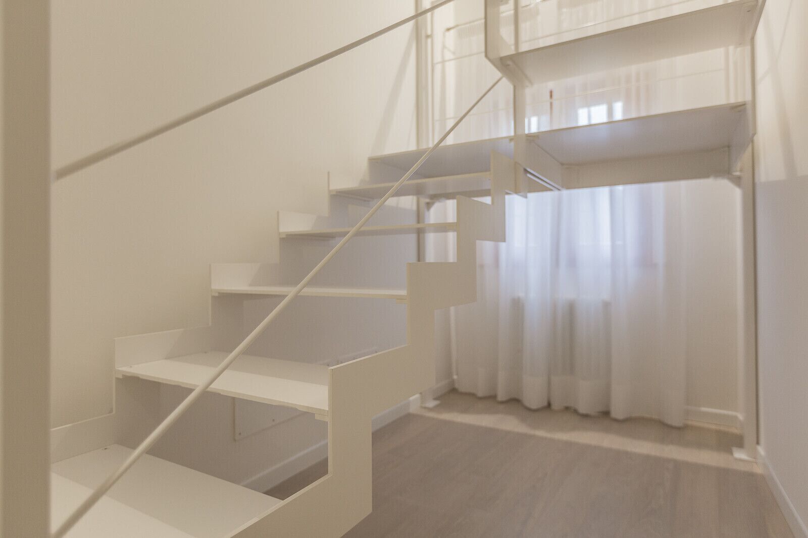 A staircase with white railings and a wooden floor.