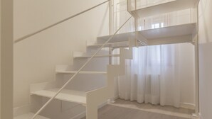 Un escalier avec des rampes blanches et un plancher en bois.