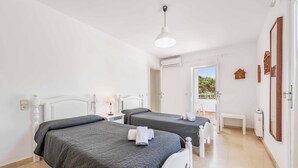 A hotel room with two beds, a balcony, and an air conditioning unit. - Villa Fort View - Four Bedroom Villa, Sleeps 8 (Santanyí)