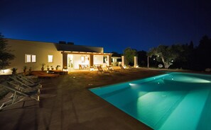 Une maison moderne dotée d’une piscine, d’un espace salon extérieur et d’un patio.