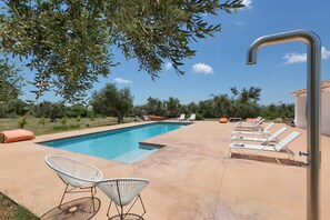 Ein Swimmingpool mit Liegestühlen und einer Wassersäule.