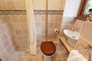A bathroom with a wooden toilet, a white sink, and a shower area. - The Granary, Luxborough (Luxborough)