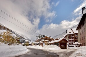 Een bergresort bedekt met sneeuw met gebouwen, waaronder een lodge aangeduid met 