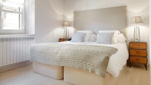 A bedroom with a large bed, bedside lamps, a window, and a radiator. - Val de Ruda Luxe 52 by FeelFree Rentals (Baqueira)