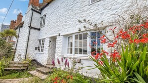 A white stone house with a brick chimney, a front door, and windows. - The Crows Nest, Porlock Weir (Somerset)