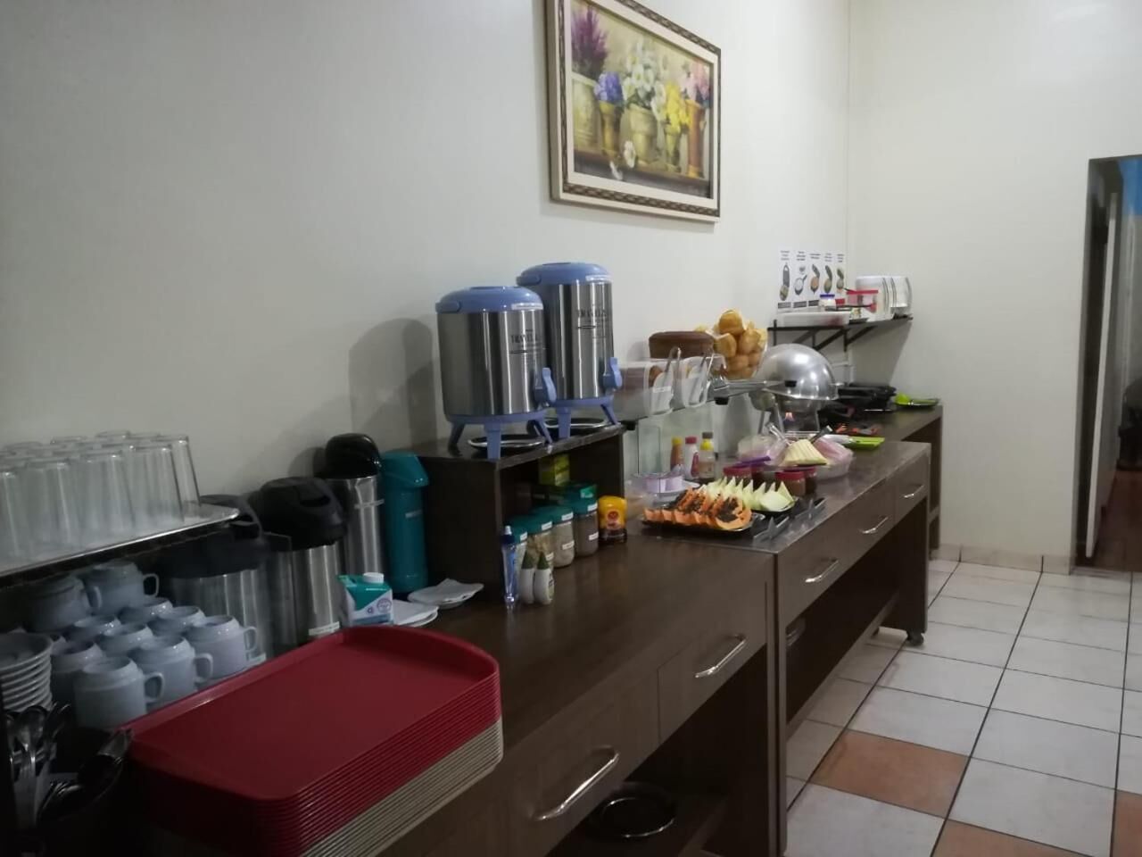A kitchen with stainless steel appliances, a red tray, and various food items on the counter.