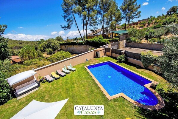 A pool area with a white canopy and lounge chairs, surrounded by lush greenery and a hillside backdrop. - Modern and spacious w/ private pool close to BCN (Sentmenat)