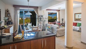 Un'ampia zona giorno con cucina, tavolo da pranzo e vista sull'esterno.