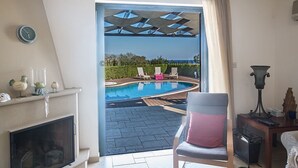 Una stanza con camino, piscina e vista sull'esterno.