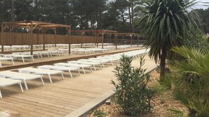 A wooden deck with white lounge chairs and a wooden pergola structure. - OCEANBAHIA12 rental luxury 6 pers Club 5 * clim Montalivet Aquitaine  (Vendays-Montalivet)