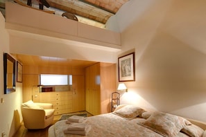 Une chambre à coucher avec un lit, une chaise, un bureau et une fenêtre.