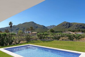A swimming pool with a view of mountains and a clear sky.