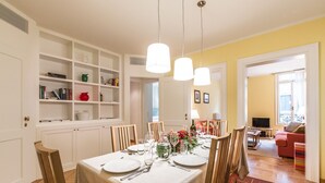 A dining area with a table set for four, surrounded by white cabinets and shelves. - Ca' Dei Nomboli Canal View (Venice)