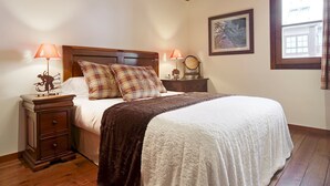 A bedroom with a large bed, two bedside tables with lamps, a wooden headboard, a framed picture on the wall, and a window with curtains. - Val de Ruda 31 by FeelFree Rentals (Baqueira)