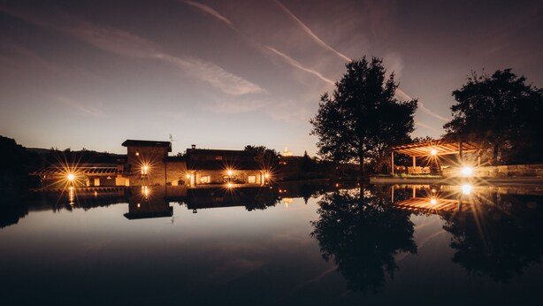 A lakeside hotel with a reflection of the buildings and trees.