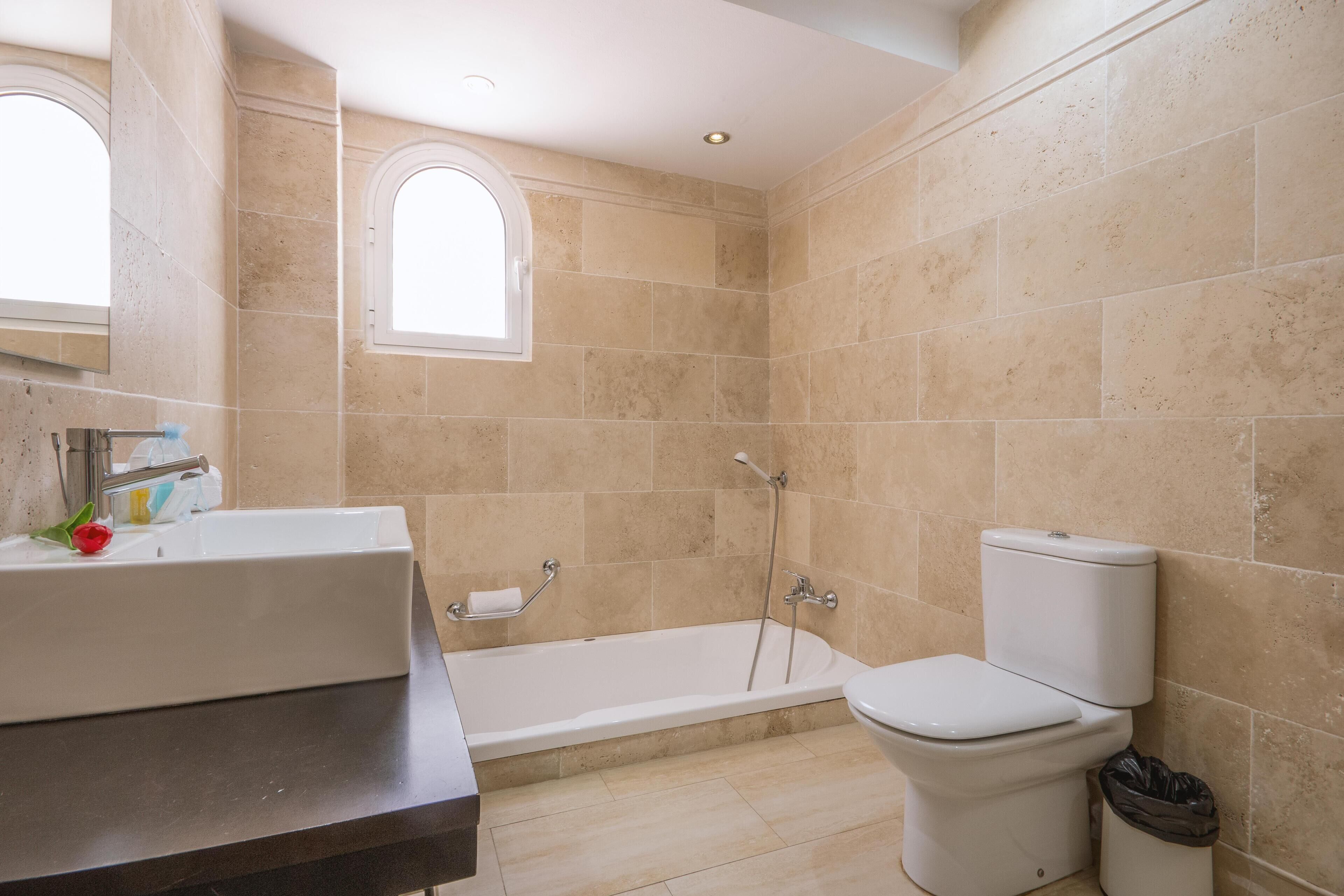 A bathroom with a bathtub, toilet, and sink.