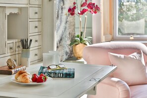 A neatly arranged breakfast table with croissants, strawberries, and a book titled 'English' by Kate Fox.