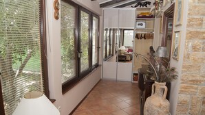 A hallway with a tiled floor, a lamp, a vase with decorative peacock feathers, and a wardrobe with a mirror. - House with pool in Split near the beach (Split)