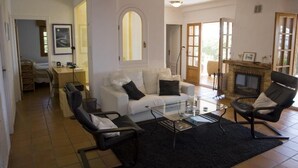 A living room with a white sofa, black chairs, a glass coffee table, and a fireplace. - Finca el Tossal, Altea (Altea)