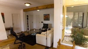 A living room with a glass coffee table, white sofa, and black chairs. There is a wooden bench and a potted plant. - Finca el Tossal, Altea (Altea)