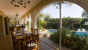 A dining area with a view of a swimming pool and garden. - Finca el Tossal, Altea (Altea)