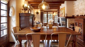 A dining area with a wooden table and chairs, a large bowl, and a hanging light fixture. - Solei by FeelFree Rentals (Garòs)