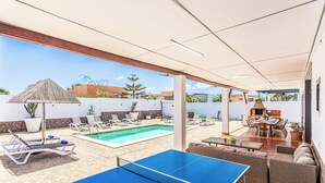 A pool area with a ping pong table, lounge chairs, and a barbecue area. - Villa Susi - Five Bedroom Villa, Sleeps 10 (Fuerteventura)