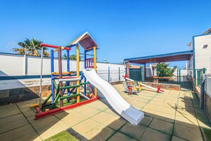 Ein Spielplatz mit Rutsche und Klettergerüsten.