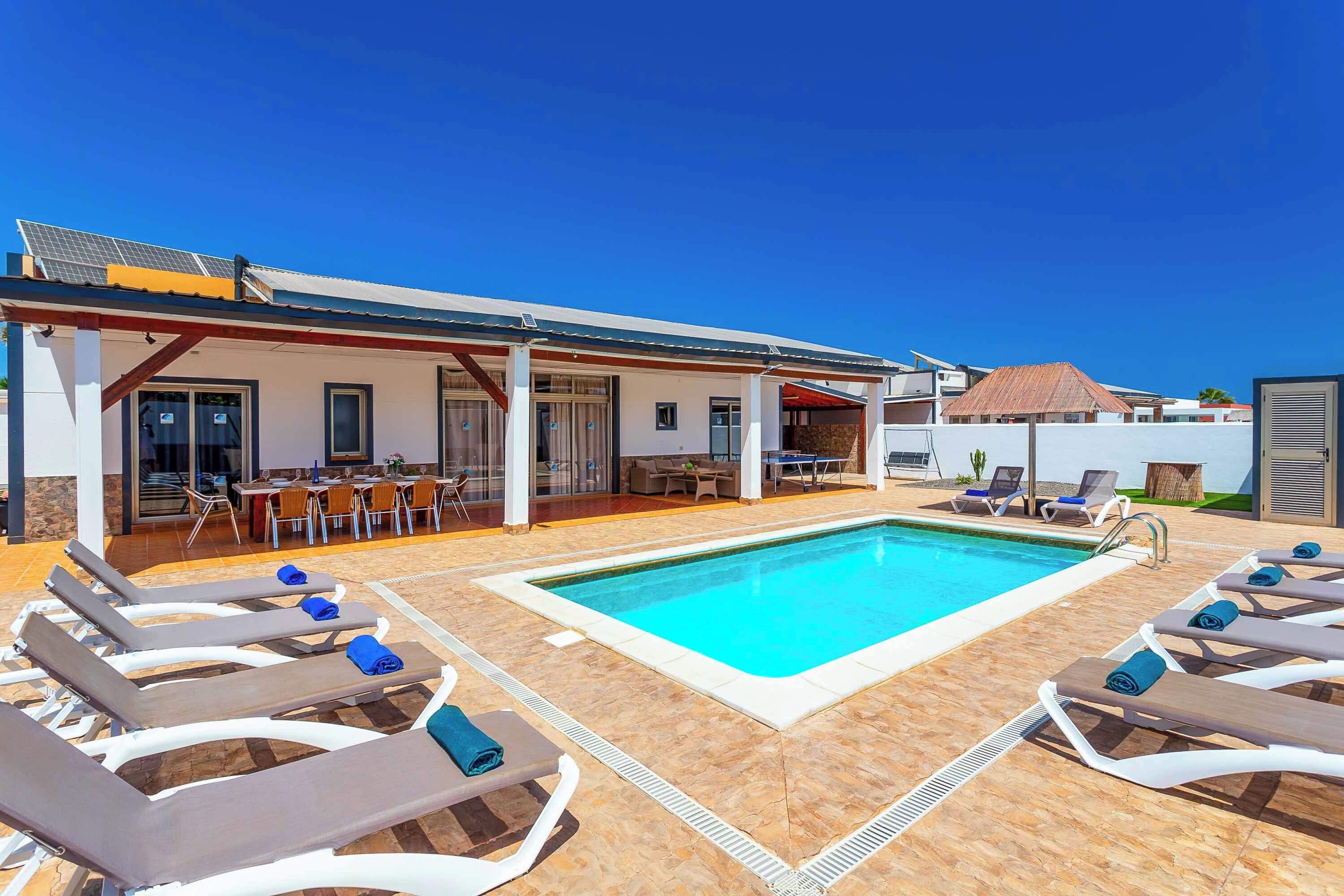 A poolside area with lounge chairs and a dining setup.