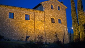 A stone building with multiple windows and a tower. - Old Stone Apartment Perona (Cinigiano)