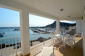 Een balkon met uitzicht op een jachthaven en stadsbeeld.