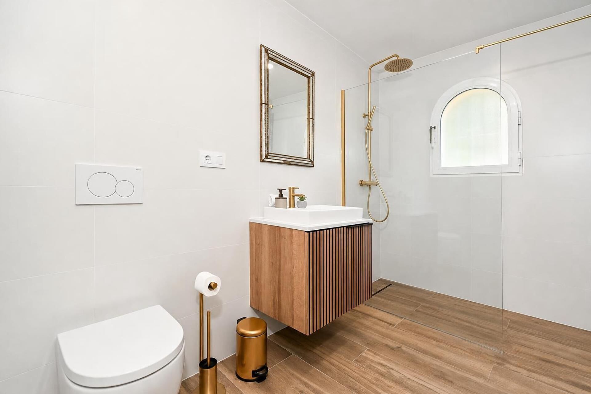 A modern bathroom with a toilet, sink, and shower.