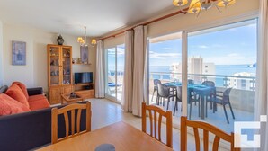 A spacious living room with a large sliding glass door leading to a balcony with a view of the sea. - Apolo XVIII 57 - Grupo Turis - Calpe, Costa Blanca (Calpe)
