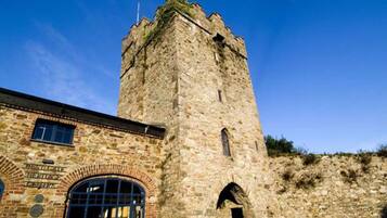A stone tower with a brick entrance and arched windows.