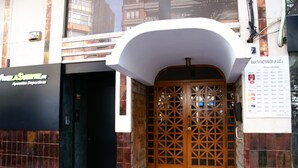 L'ingresso di un edificio con una porta in legno e un cartello sopra.