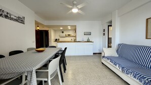Un espacio habitable compacto con comedor, kitchenette y sofá.