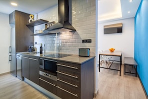 A modern kitchen with a built-in oven, a toaster, and a sink.
