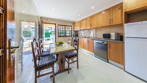 Une cuisine moderne avec des meubles en bois, un lave-vaisselle en acier inoxydable et un réfrigérateur blanc.
