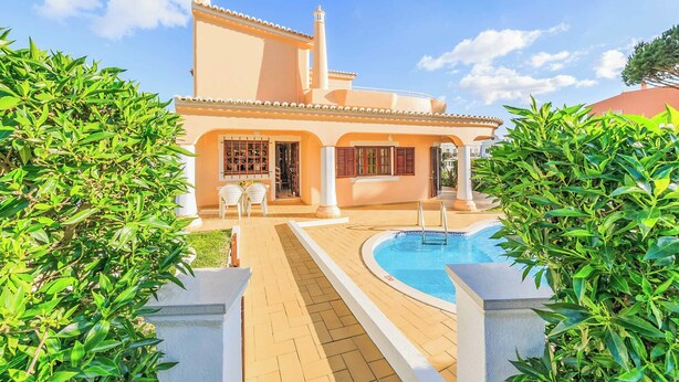Une grande maison avec une piscine, entourée d’une végétation luxuriante.