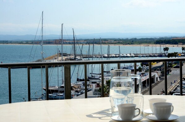 A balcony with a view of a marina and beach.