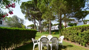 A garden with a table and chairs, surrounded by trees and hedges. - PIVERD DEL GOLF 56 (Pals)